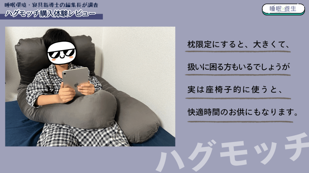 ハグモッチ抱き枕を使っている人が、座ってタブレットで何かを見ている様子。背景はシンプルで、リラックスした雰囲気を演出。